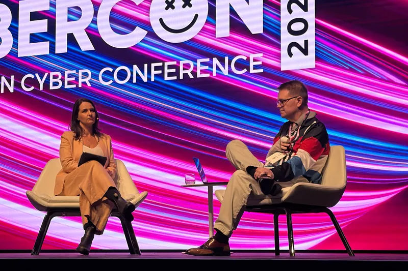 Mark Vos seated in an on-stage conversation at CyberCon 2026, in front of the Australian Cyber Conference screen